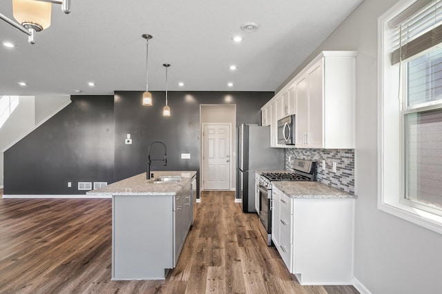 kitchen with stainless steel appliances, a sink, a kitchen island with sink, white cabinetry, and dark wood-type flooring