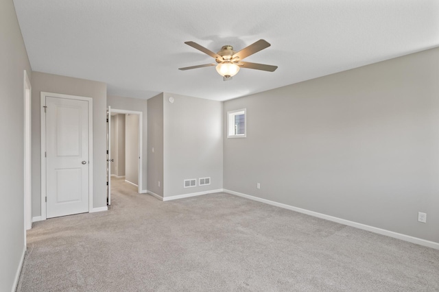 carpeted empty room with a ceiling fan and baseboards
