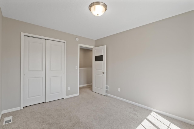 unfurnished bedroom featuring carpet floors, a closet, and baseboards