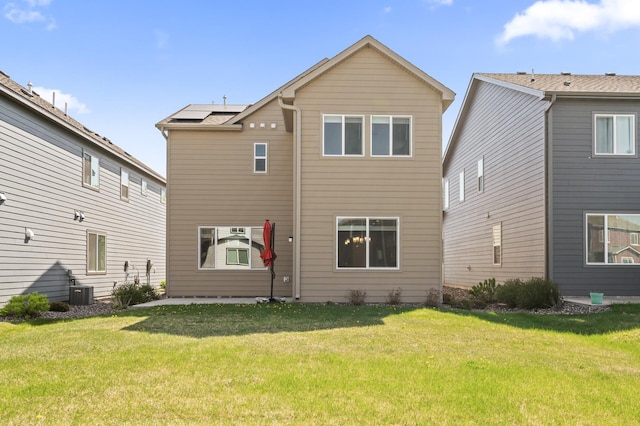 rear view of property with a lawn and central AC