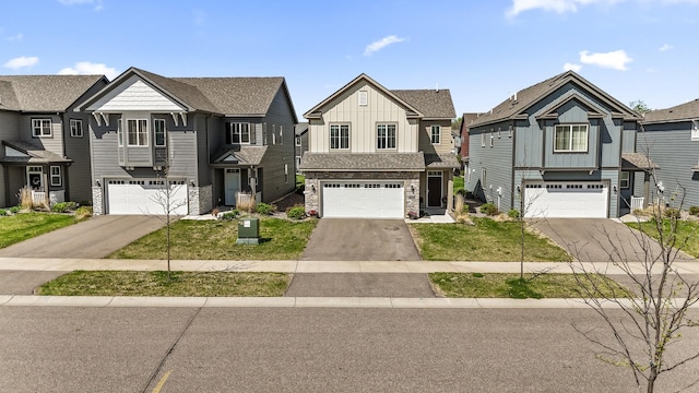 view of front of property with board and batten siding, an attached garage, stone siding, and asphalt driveway
