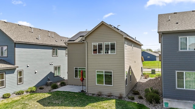 back of house with a lawn and a patio