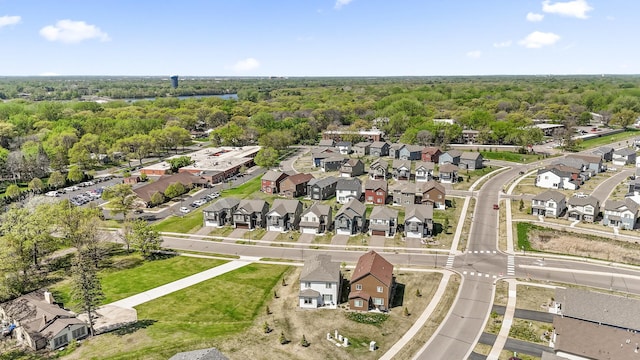 aerial view of property's location featuring a forest and nearby suburban area