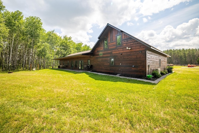 view of side of home with a yard and a wooded view