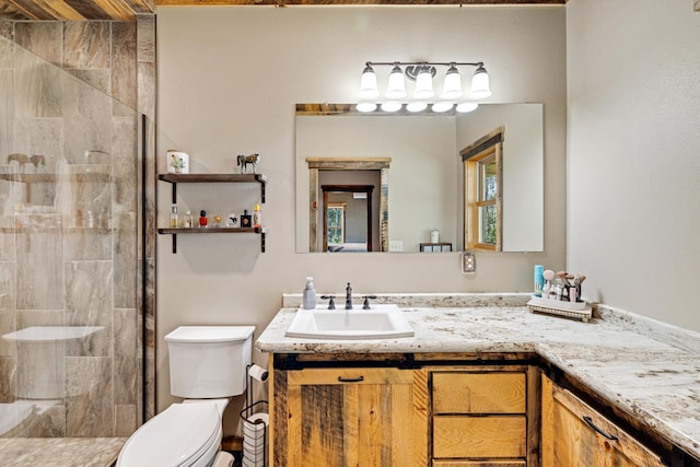 full bath featuring tiled shower, toilet, and vanity