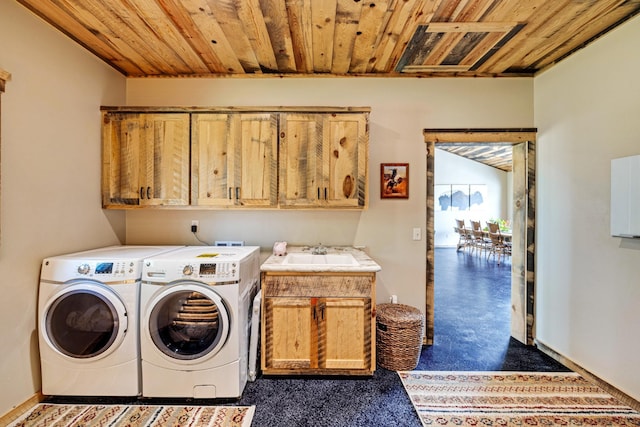 washroom featuring cabinet space, washing machine and dryer, wooden ceiling, and baseboards