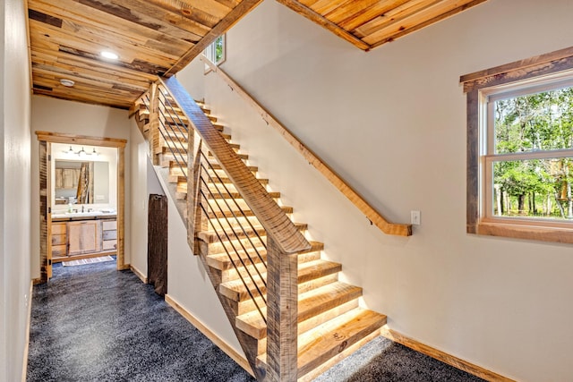 stairway featuring wood ceiling, baseboards, recessed lighting, and carpet floors