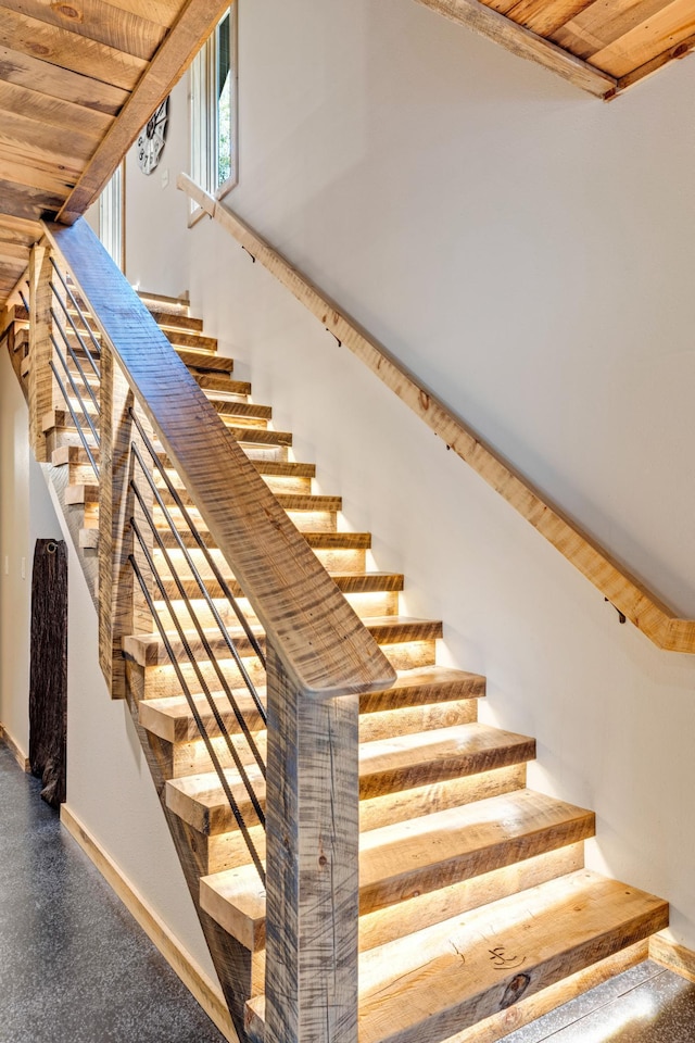 stairs with baseboards and wooden ceiling