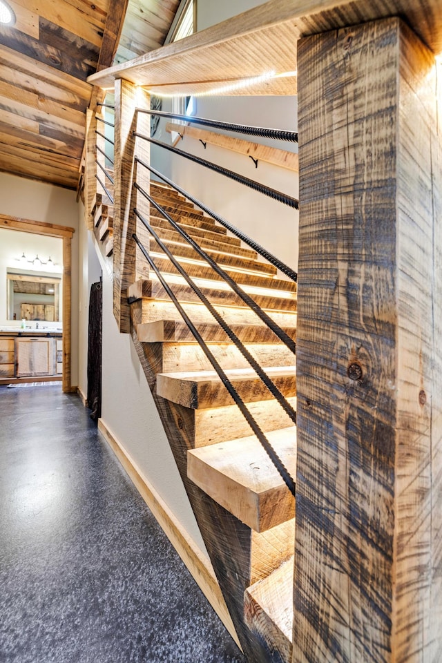 stairs with baseboards and wooden ceiling