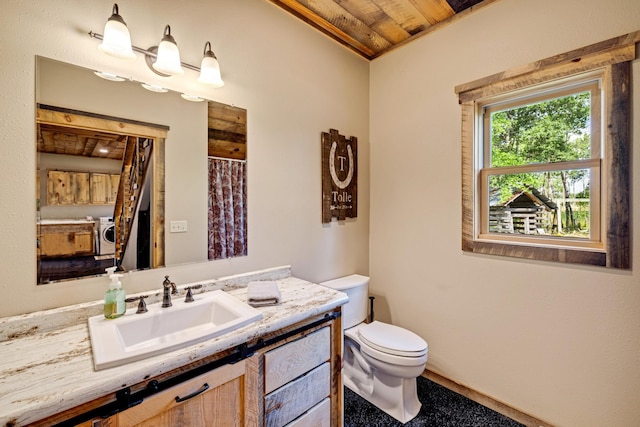 bathroom with wood ceiling, toilet, vanity, washer / clothes dryer, and a shower with curtain