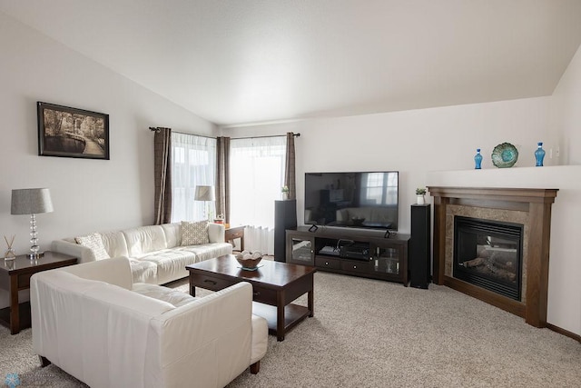 carpeted living area with lofted ceiling and a glass covered fireplace