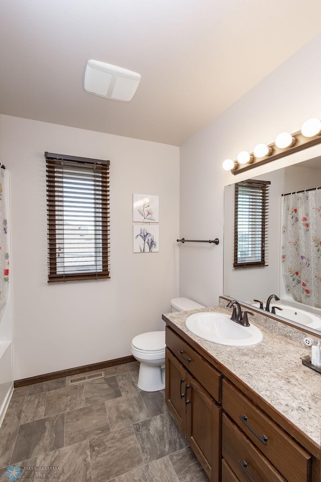 bathroom featuring baseboards, toilet, and vanity