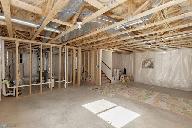 unfinished below grade area featuring stairway and water heater