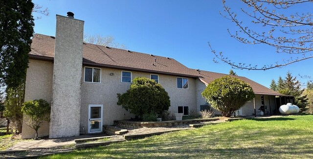 29441 108th St NW, Princeton, MN 55371 - back of property with stucco siding, a lawn, and a chimney