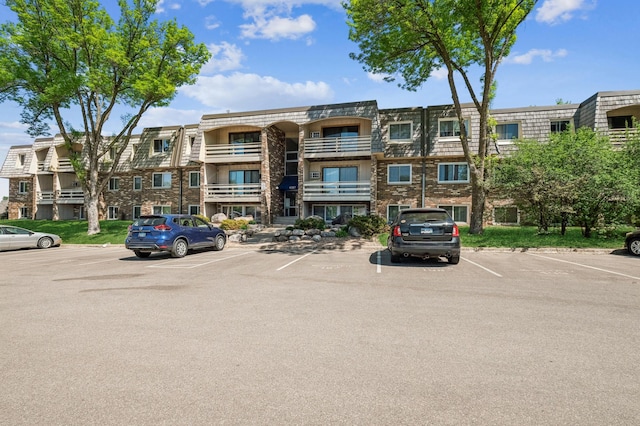 view of apartment building / complex with uncovered parking