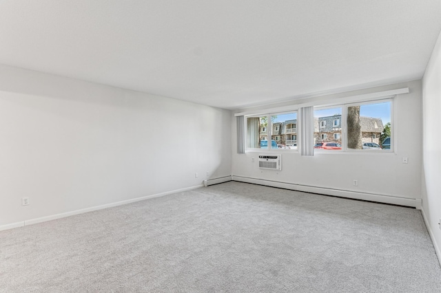 spare room featuring a baseboard heating unit, carpet, baseboards, and a wall mounted air conditioner