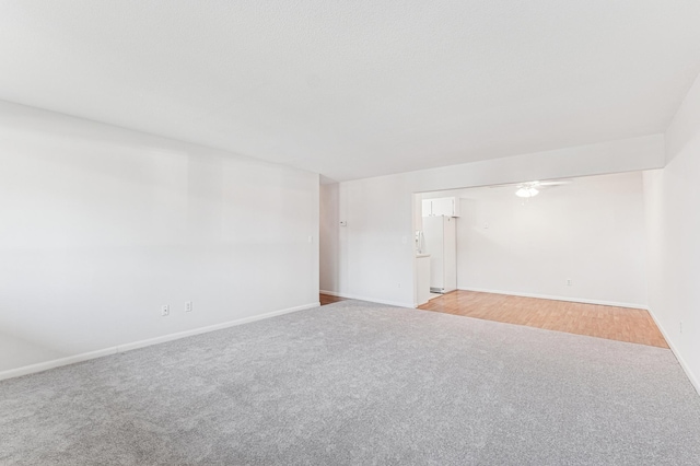 unfurnished room with light carpet and baseboards