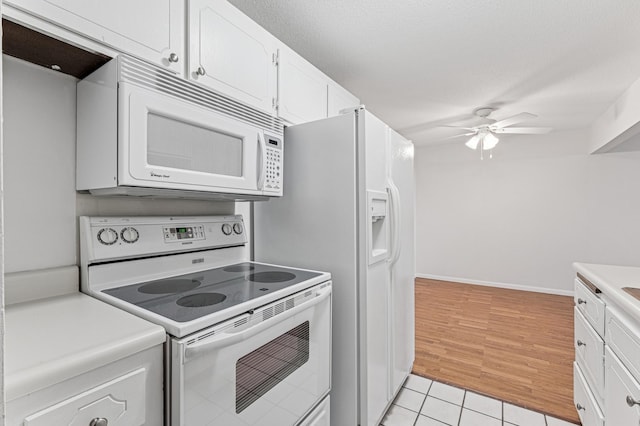 kitchen with white appliances, a ceiling fan, white cabinetry, light countertops, and light tile patterned floors