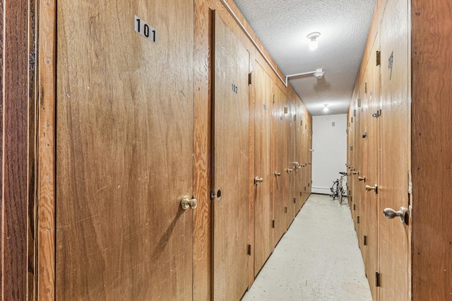 hallway featuring a textured ceiling and concrete flooring