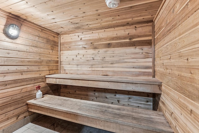 relaxing sauna / steam room with wood walls, wooden ceiling, and tile patterned flooring
