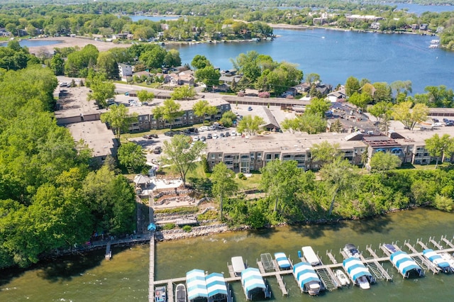 drone / aerial view of a nearby body of water and a tree filled landscape