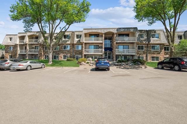view of apartment building / complex with uncovered parking