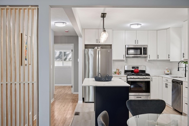 3544 Lee Ave N, Crystal, MN 55422 - kitchen with stainless steel appliances, a sink, light wood finished floors, decorative backsplash, and a kitchen island