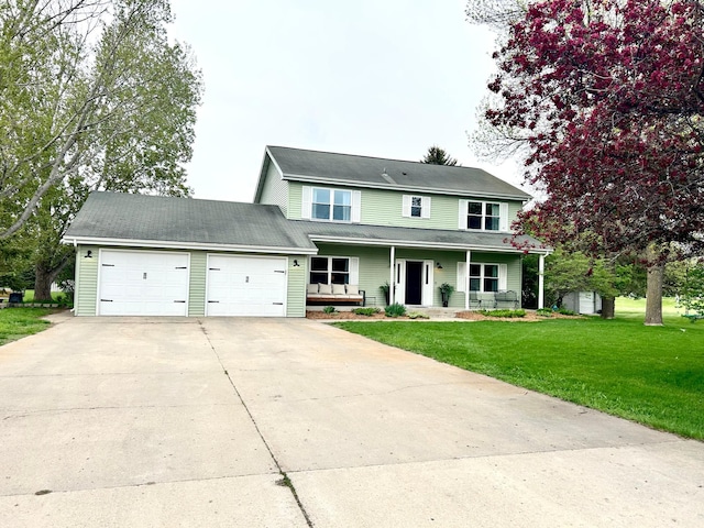 view of front of house with a porch, an attached garage, driveway, and a front yard