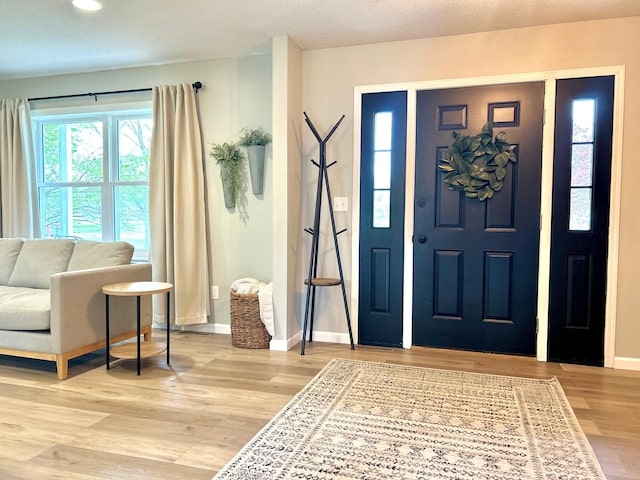 entryway with light wood finished floors, baseboards, and recessed lighting