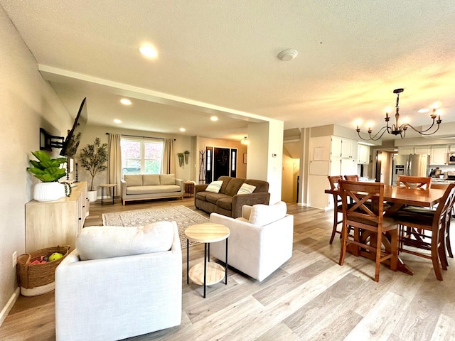 living room with light wood-type flooring, a chandelier, recessed lighting, a textured ceiling, and baseboards