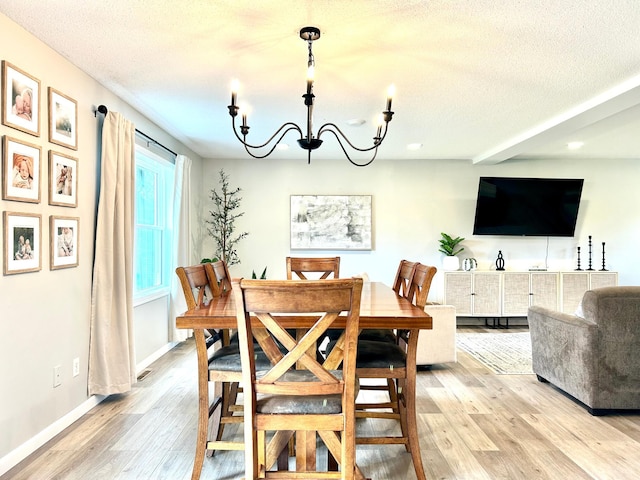 dining area featuring a chandelier, light wood-type flooring, a textured ceiling, recessed lighting, and baseboards
