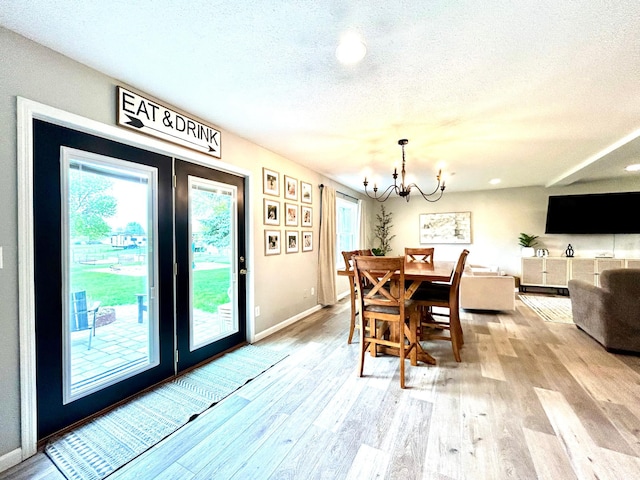 dining room featuring a chandelier, a textured ceiling, light wood-style floors, baseboards, and recessed lighting
