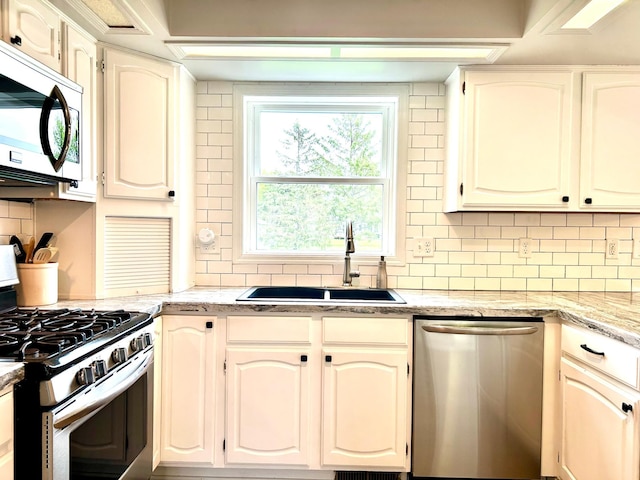 kitchen with stainless steel appliances, a sink, and backsplash