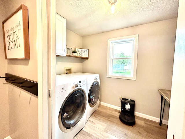 laundry area with washing machine and dryer, cabinet space, light wood finished floors, baseboards, and a textured ceiling