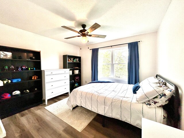 bedroom with wood finished floors, a ceiling fan, and a textured ceiling