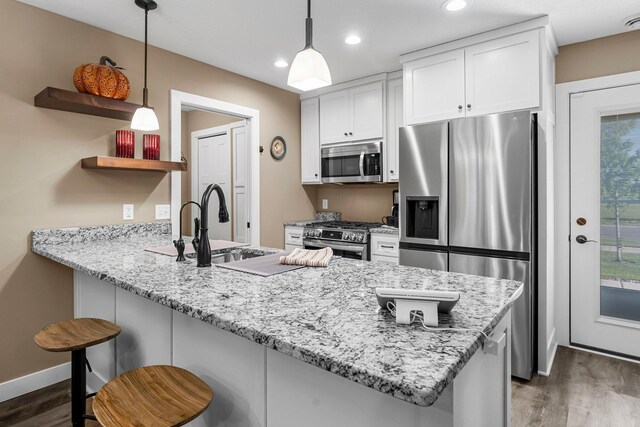 38760 Maple Ct, North Branch, MN 55056 - kitchen with appliances with stainless steel finishes, a sink, dark wood-style flooring, a peninsula, and open shelves