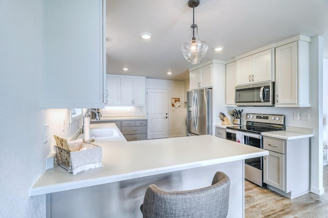 26533 Paradise Point Rd, Detroit Lakes, MN 56501 - kitchen with stainless steel appliances, a sink, a peninsula, light wood-style floors, and light countertops