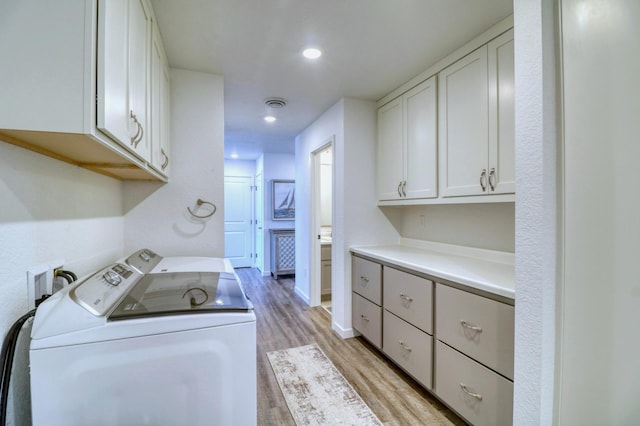 26533 Paradise Point Rd, Detroit Lakes, MN 56501 - clothes washing area with washer and clothes dryer, cabinet space, light wood-style flooring, recessed lighting, and baseboards