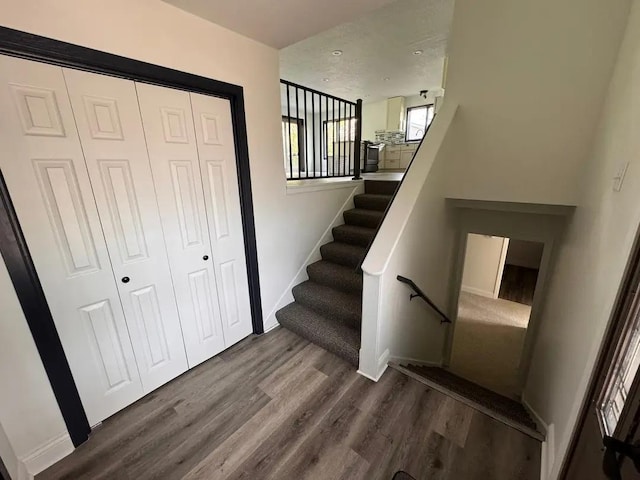 staircase with wood finished floors and baseboards