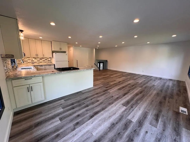 kitchen with a sink, dark wood-type flooring, freestanding refrigerator, and recessed lighting