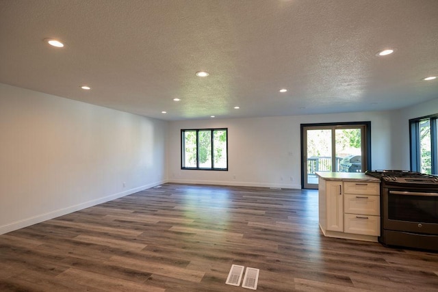 408 19th St NW, Willmar, MN 56201 - kitchen with stainless steel range with gas stovetop, recessed lighting, open floor plan, a textured ceiling, and white cabinets