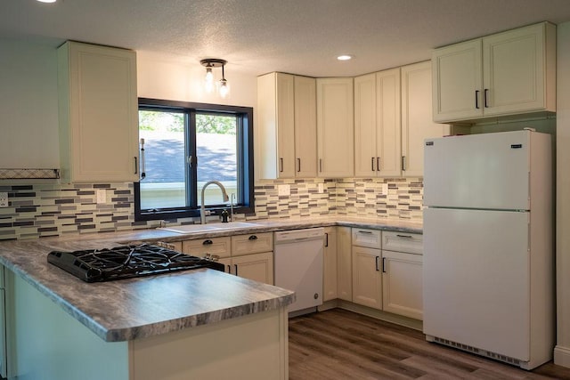 408 19th St NW, Willmar, MN 56201 - kitchen featuring white appliances, a sink, backsplash, dark wood-type flooring, and white cabinets