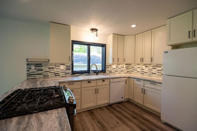 408 19th St NW, Willmar, MN 56201 - kitchen featuring white appliances, a sink, dark wood-style flooring, backsplash, and white cabinets
