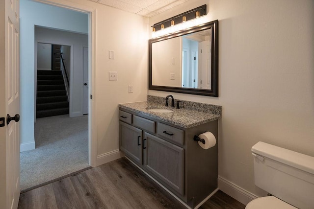 408 19th St NW, Willmar, MN 56201 - bathroom with wood finished floors, toilet, vanity, and baseboards