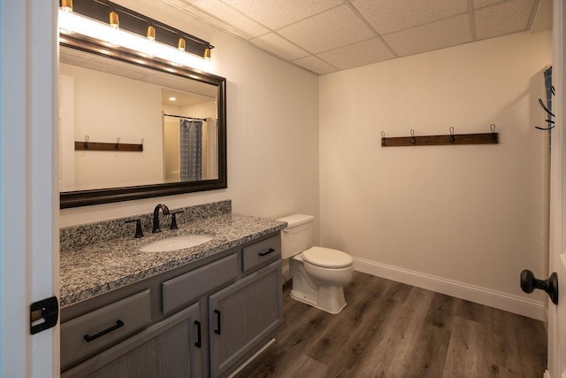 408 19th St NW, Willmar, MN 56201 - bathroom with a paneled ceiling, wood finished floors, toilet, vanity, and baseboards