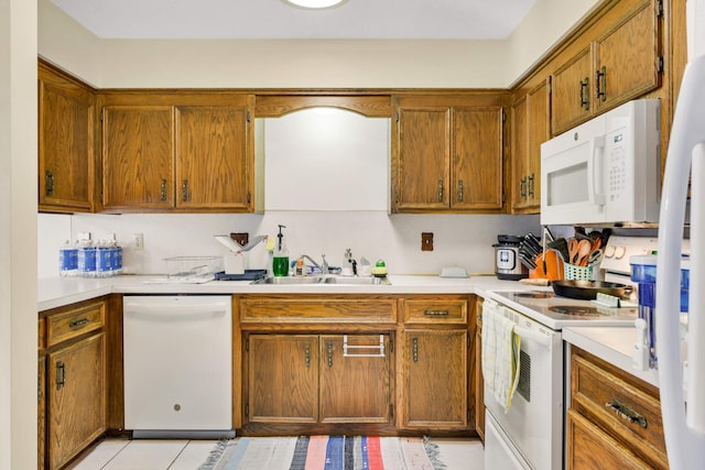 11110 Utica Ave S, Bloomington, MN 55437 - kitchen featuring white appliances, a sink, light countertops, brown cabinetry, and light tile patterned flooring