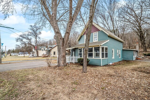 444 Vincent St, Saint Croix Falls, WI 54024 - view of side of home featuring a sunroom and roof with shingles