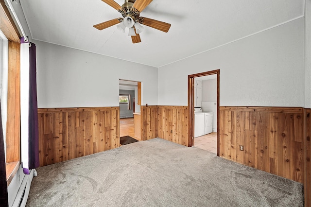 444 Vincent St, Saint Croix Falls, WI 54024 - spare room featuring wainscoting, wooden walls, washer and clothes dryer, ceiling fan, and carpet