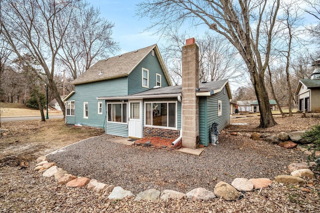 444 Vincent St, Saint Croix Falls, WI 54024 - rear view of house with a chimney, a sunroom, and roof with shingles