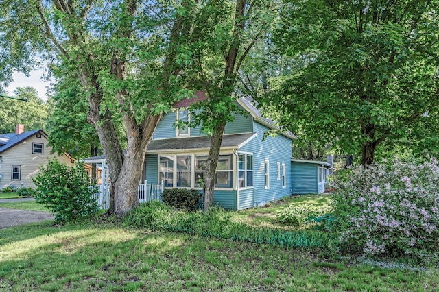 444 Vincent St, Saint Croix Falls, WI 54024 - view of front of house with a sunroom and a front lawn